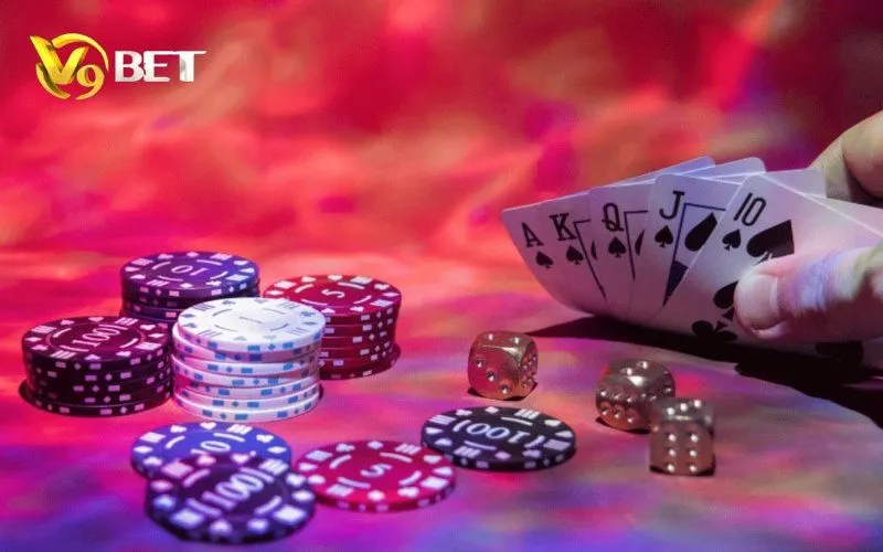 Poker V9BET | Luật Chơi, Thứ Tự Bài, Blind & All-in 3 Các lá A, K, Q, J, 10 cạnh chồng chip và ba xúc xắc.